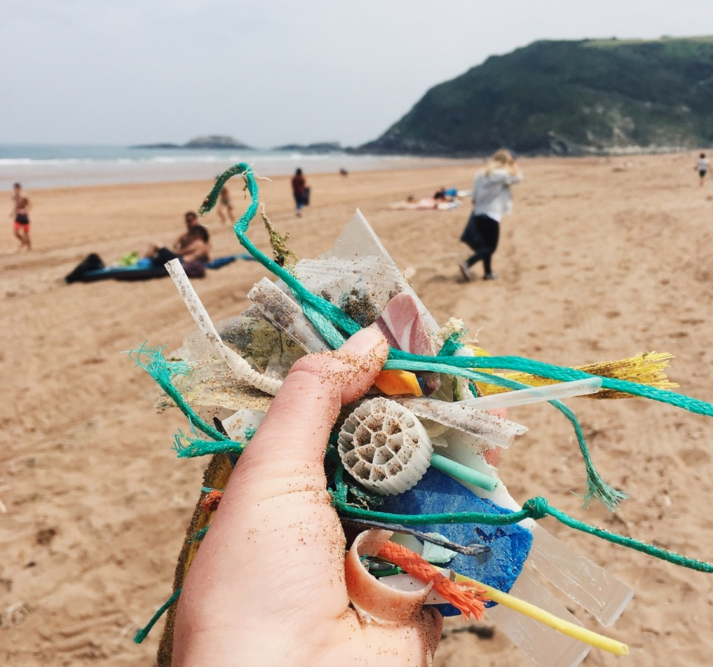 foto de Sufririder con desechos plásticos de la playa